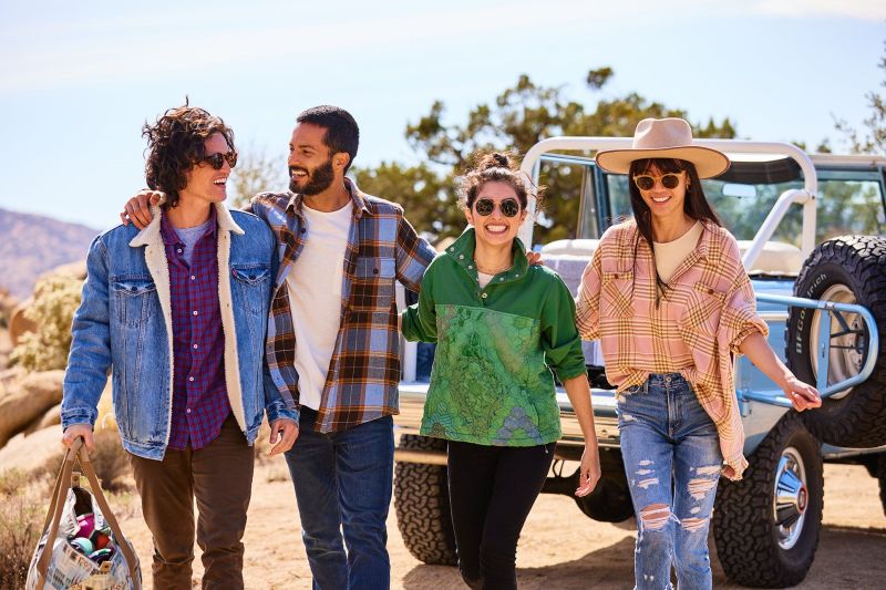 Group of friends walking in front of a Ford Bronco vintage, turquoise in the California Desert