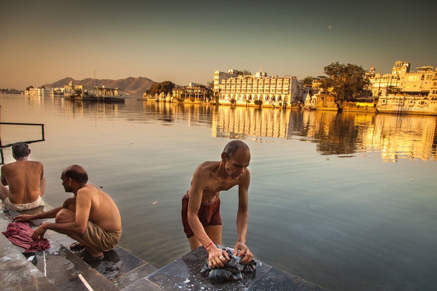 Lake Pichol, Rajasthan. Men bathing in an early morning warm day