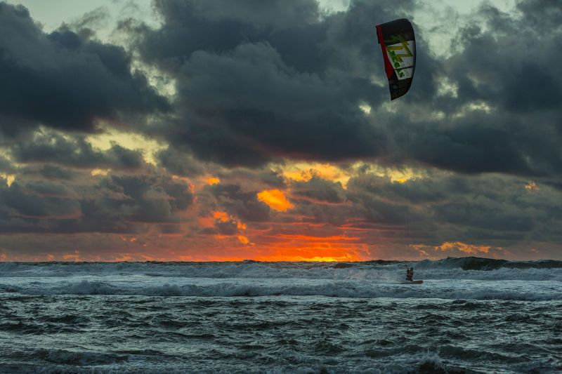 Kit surfer at the Ocean Beach in San Francisco at sunset