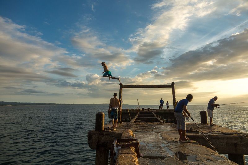Playa Crash Boat Puerto Rico at sunset with fishermen and people jumping from the old pier