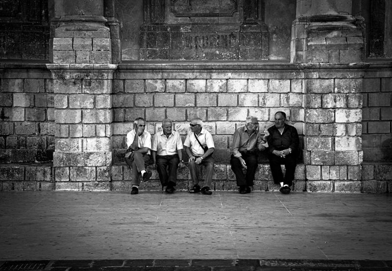 Sicilian men talking on the main square of Noto, Sicily