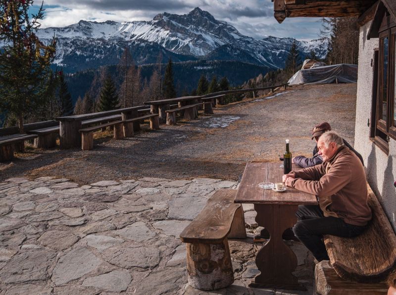 Friends drinking with the view of the Julian Alps in Sauris