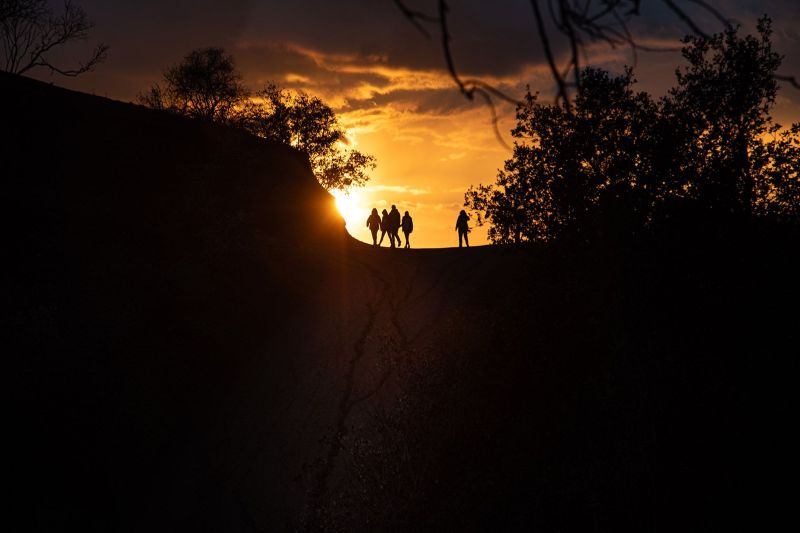 Silhouette of hikers at the Griffith Park hiking trail at sunset