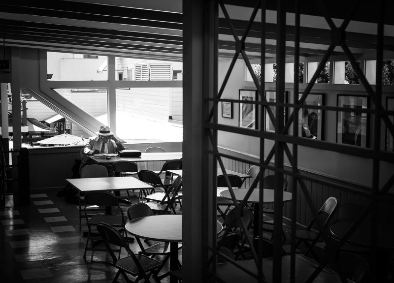 Noir Farmers Market in Los Angeles with elegant man reading a book