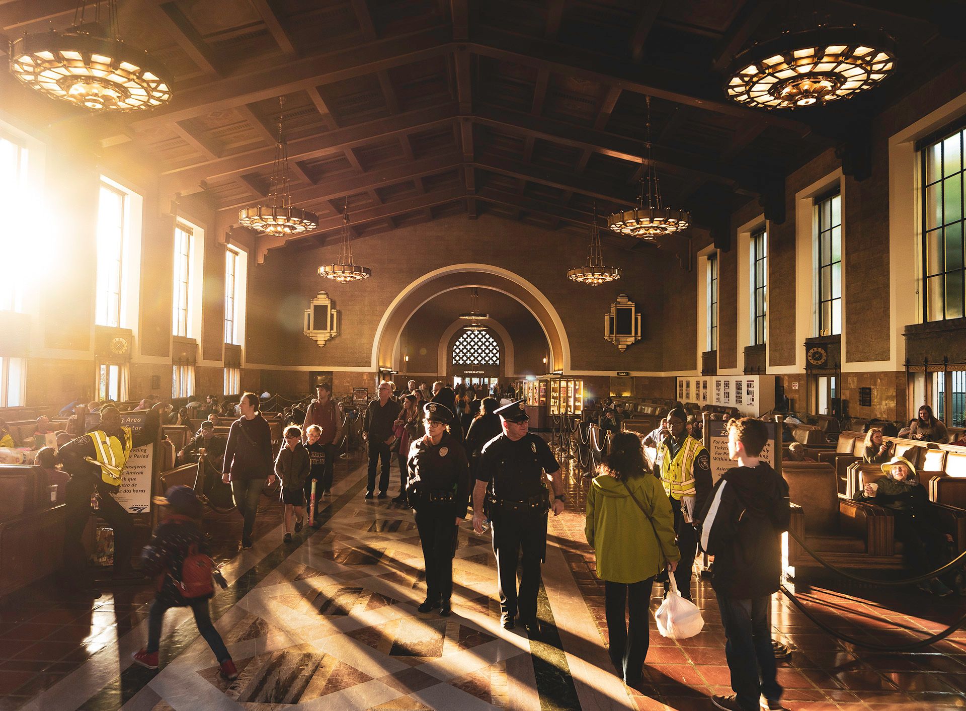 Union station waiting room art deco masterpiece with cops in the foreground and sun shining through the window
